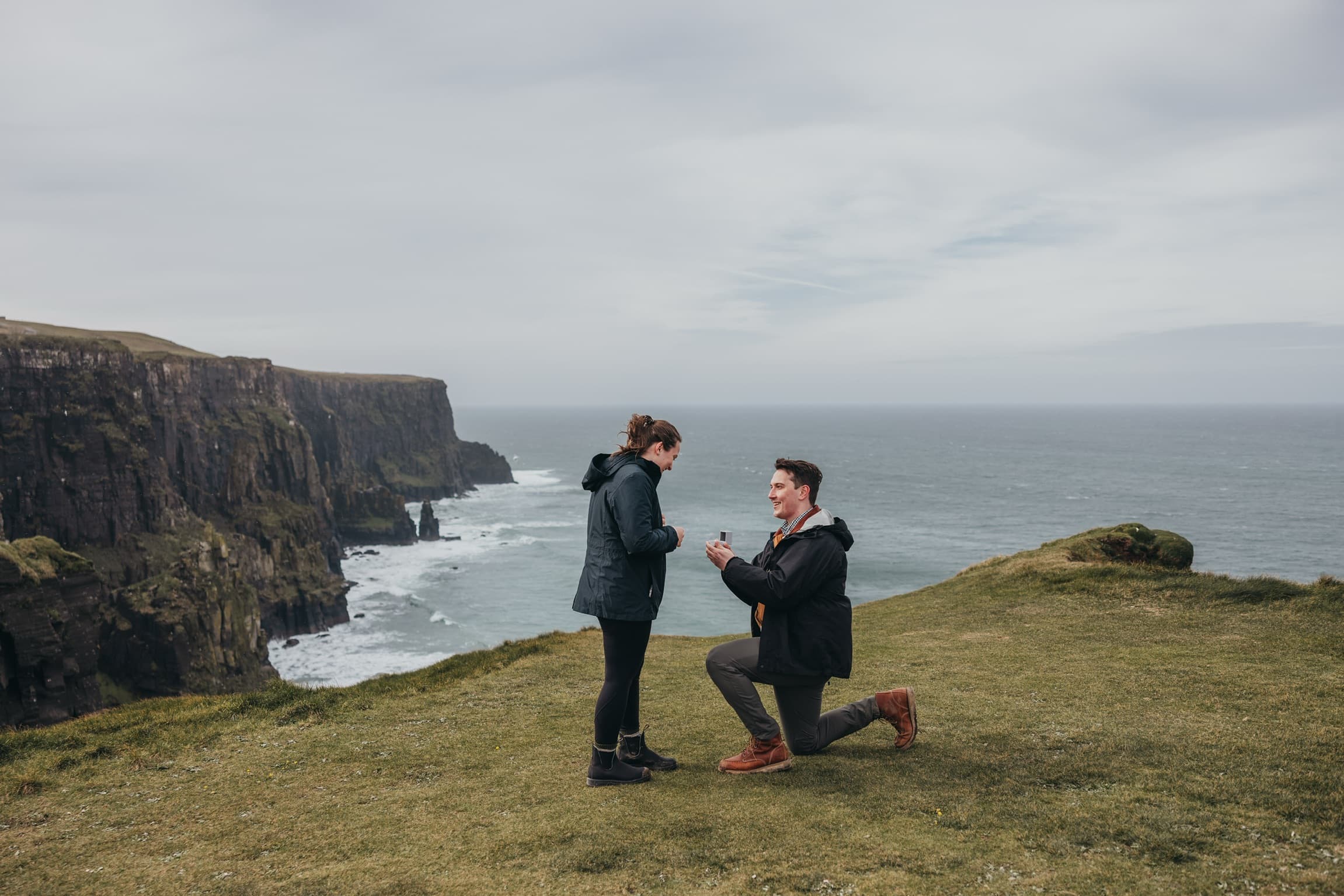 Jake proposing to Victoria on a coastal cliff